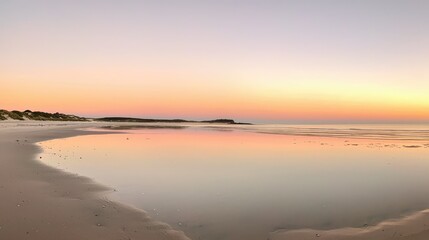 Serene Beach at Sunset with Calm Waters and Colorful Sky Reflections