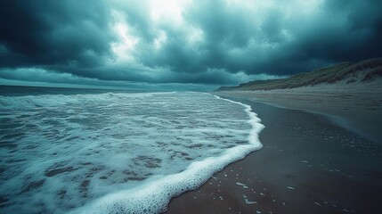 Dramatic ocean waves crashing on a dark beach under a stormy sky