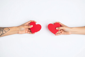 Two hands holding red heart shaped boxes on white