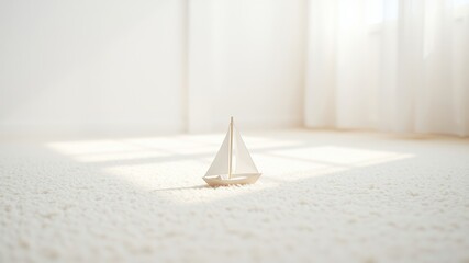 A small wooden sailboat rests on a white carpet, bathed in the soft glow of natural light, creating a tranquil scene of serenity and calm.