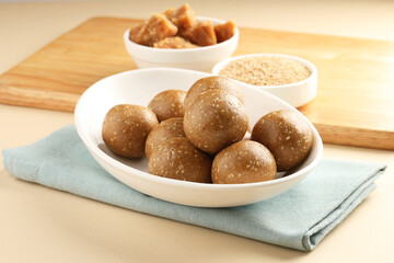 Tilgul Laddu or Til Gul balls for makar sankranti, it's a healthy food made using sesame, crushed peanuts and jaggery. served in a bowl. selective focus showing details.