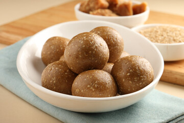 Tilgul Laddu or Til Gul balls for makar sankranti, it's a healthy food made using sesame, crushed peanuts and jaggery. served in a bowl. selective focus showing details.