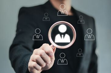 Human Resource Management, Hand holding Magnifier glass focus to manager icon which is among staff...