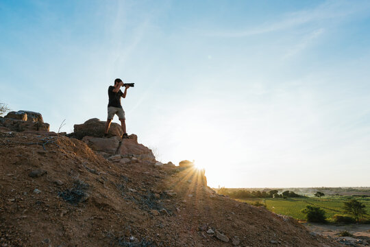 Side view of man photographer taking photos with telephoto lens