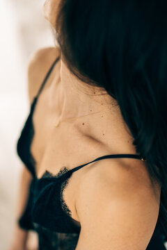 Close-up of a woman&rsquo;s collarbone with a black lace strap and necklace