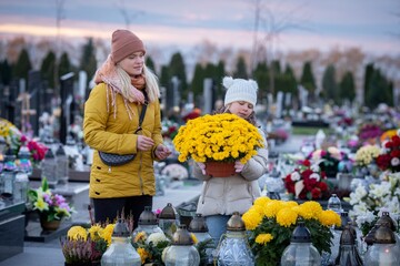 A mother and her child visit a beautiful flowered cemetery, honoring memories in autumn