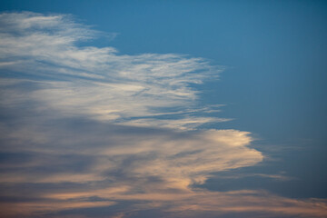 Soft, billowy clouds beautifully contrast against a stunning, vibrant blue sky during dusk