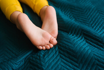 Children's feet and heels on a dark blue bed. Importance of sleep for babies. Sleep mode babies 5 y.o