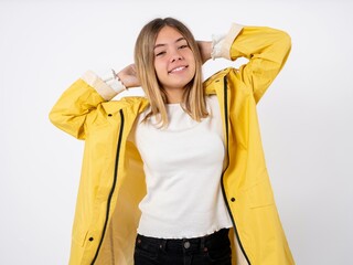 Beautiful teen girl wearing rain coat stretching arms, relaxed position.