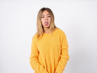 Beautiful caucasian teen girl wearing orange sweater yawns with opened mouth stands. Daily morning routine