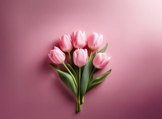 A delicate bouquet of five light pink tulips arranged on a soft pink background.  The image evokes feelings of springtime and serenity.