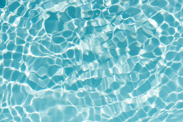 Fototapeta premium Blue water with ripples on the surface. Defocus blurred transparent blue colored clear calm water surface texture with splashes and bubbles. Water waves with shining pattern texture background.