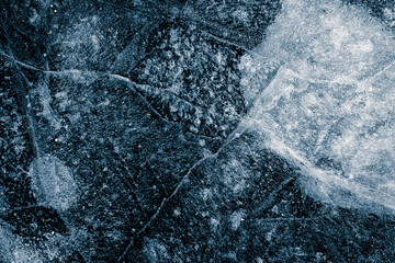 Ice texture background. The textured rough cold frosty surface of the ice on a black background.