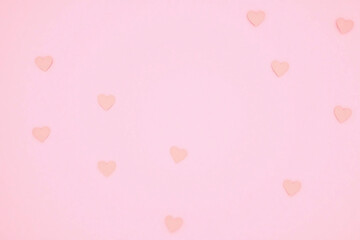 Small paper hearts in soft pink on pastel pink background