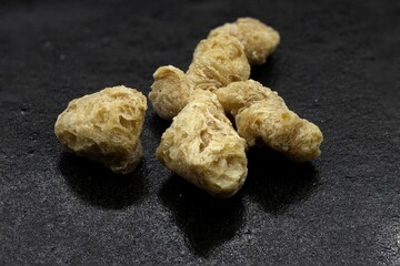 Textured Soy Protein Chunks on Dark Background, macro studio shot isolated
