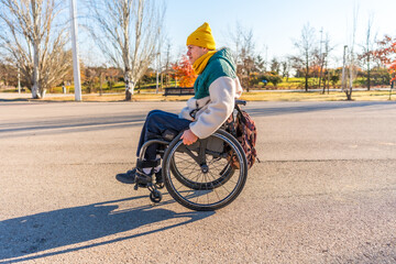 Young person using wheelchair enjoying stroll in park