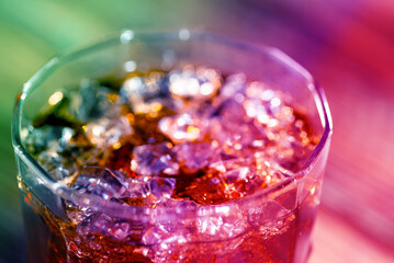 Cola and whiskey in a glass with ice cubes close-up