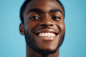 Obraz premium Close up portrait of happy young black man against blue background