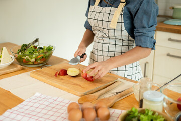 A woman cutting an apple in the kitchen