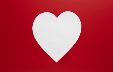 Heart shape in white against a vibrant red background conveys love and emotion during an artistic display