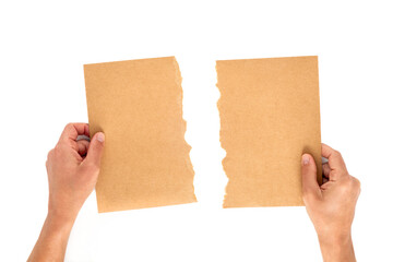 Two hands holding torn halves of a craft paper sheet on white background