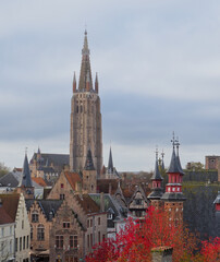 Naklejka premium A variety of pointy building spires reach for the sky on the rooftops of Bruges, Belgium skyline. 