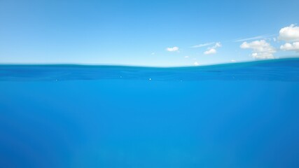 Fototapeta premium Underwater view of the ocean with a clear blue sky and wispy clouds above