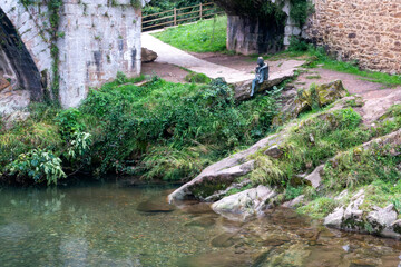 Statue of the fish man of Lierganes on the banks of the Mieres River. Cantabria, Spain.