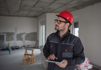 Construction engineer working on tablet in apartment during renovation
