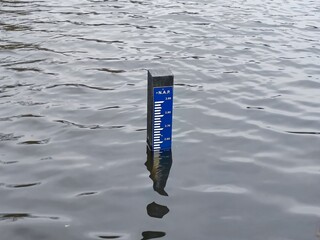 Tilt shot of NAP Normaal Amsterdams Peil (Normal Amsterdam Level) board in a lake in the Netherlands that indicates that the water is higher than the average sea level of the North Sea