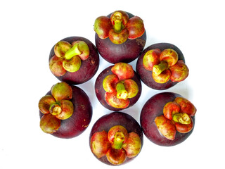 Portrait of fresh mangosteen fruit arranged in a circle in the shape of a flower with bright light on a white background. 