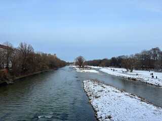 Winter View of the Isar River in Munich from Wittelsbacherbrücke with Snow-Covered Surroundings