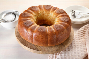 Freshly baked sponge cake served on white wooden table, closeup
