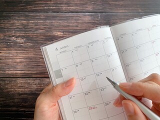 4月のスケジュール帳に書く手元