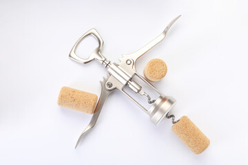 Wing corkscrew and corks on white background, top view