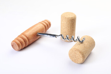 Corkscrew with wooden handle and corks on white background