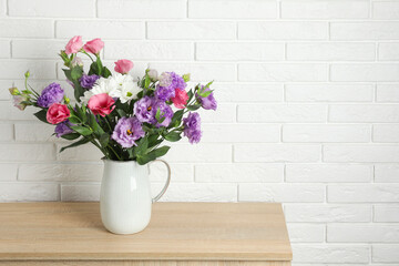 Vase with beautiful eustoma flowers on wooden chest of drawers, space for text