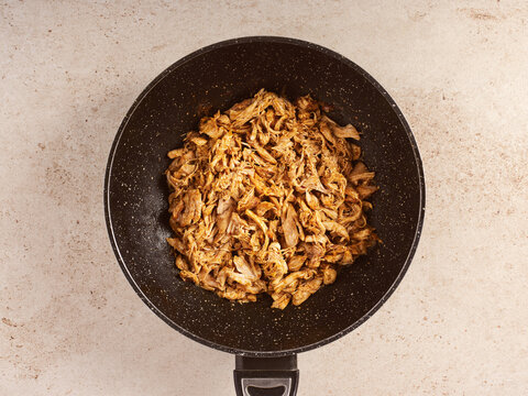 Savory Shredded Chicken Prepared in a Frying Pan With Traditional Spanish Spices and Herbs for a Delicious Meal