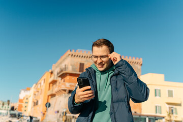 Close up of a man flipping through news on his smartphone outdoors