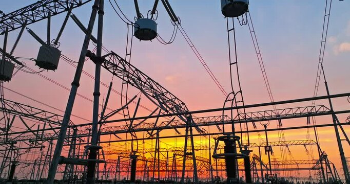 High voltage power tower in substation. Transmission power line at dusk. 
