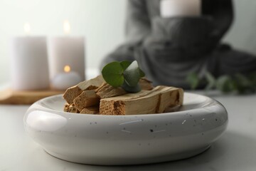 Palo santo sticks and eucalyptus leaves on white table, closeup