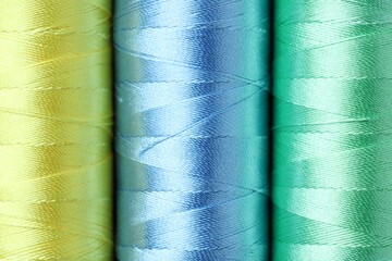 Spools of colorful sewing threads as background, top view