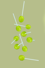 Falling green lollipops isolated on background, full depth of field.