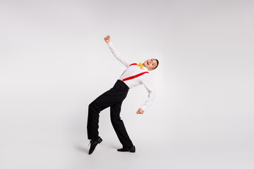 Energetic young gentleman dancing joyfully in elegant attire, showcasing glamour and retro style...