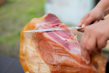 原木生ハムを切る