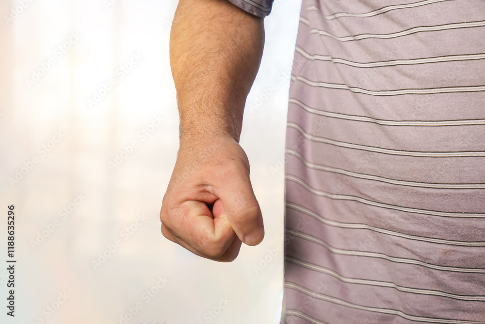 Poster man's hand in the shape of a fist on a light background