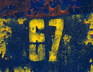 Yellow number 67 on textured background. Sixty-seven