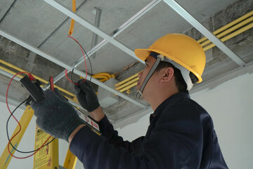 Electrician checking the current for the installation of electrical system in the house. Concept of...