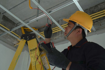 Electrician checking the current for the installation of electrical system in the house. Concept of...