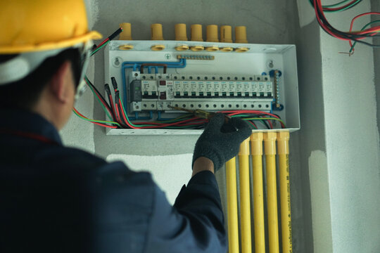 An electrician is using a device to check the electrical current for electrical installation in a home.
